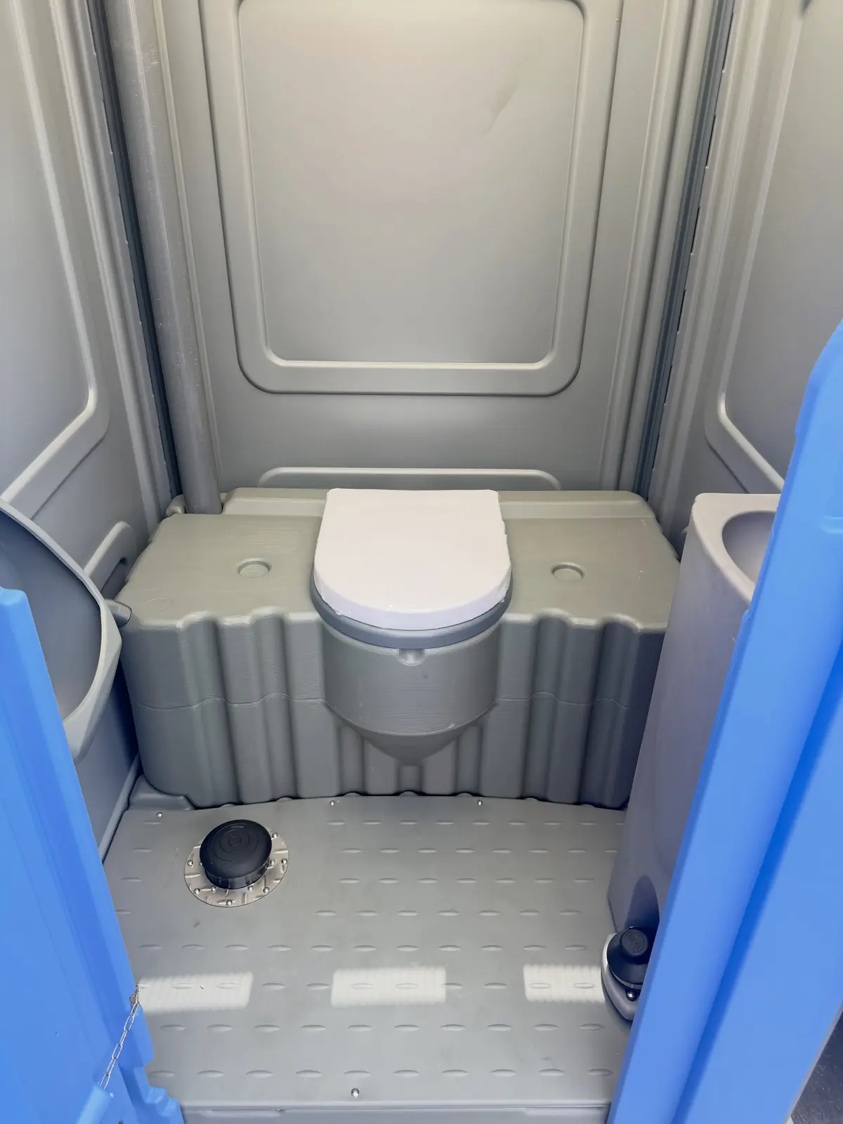 Clean toilet seat and lid inside a standard portable toilet