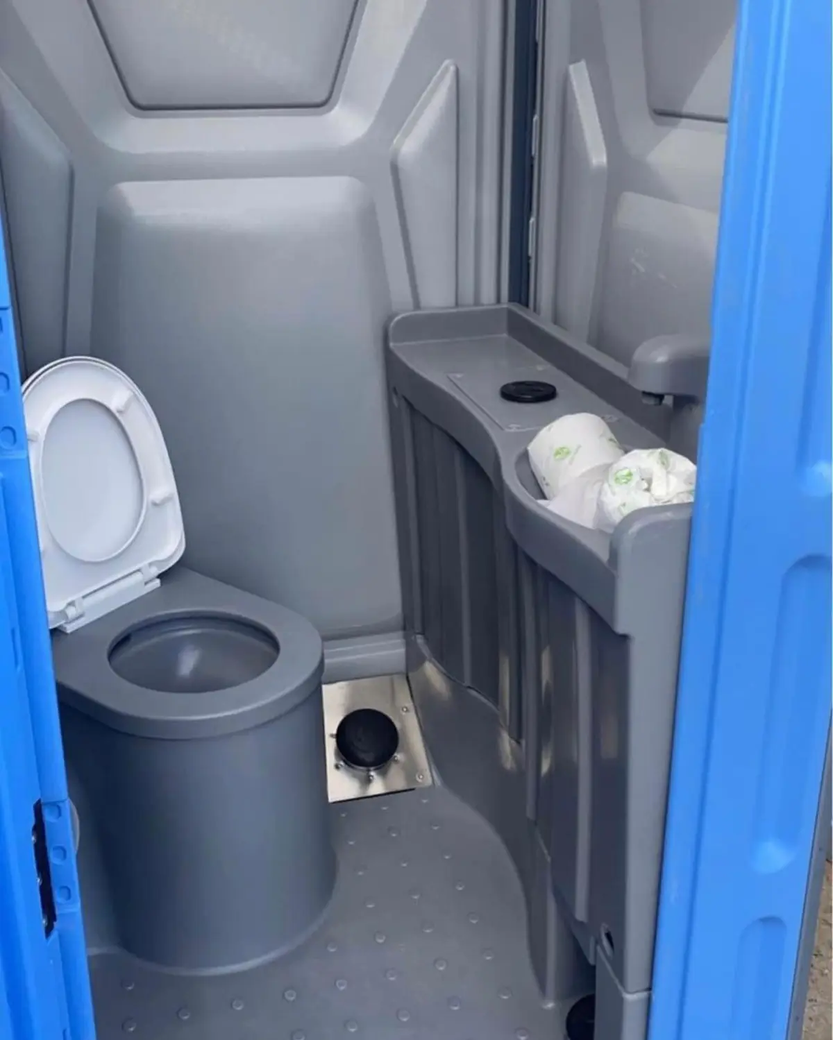 Toilet paper holder and hand sanitizer dispenser mounted inside a portable toilet
