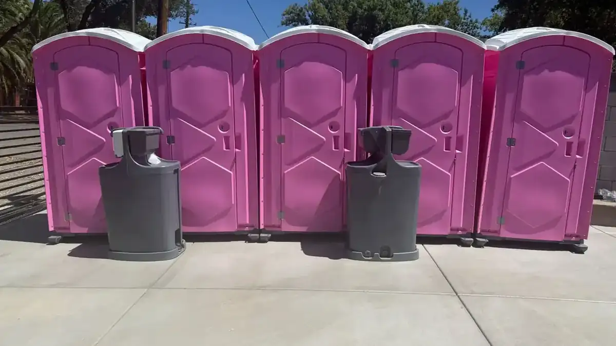 Row of portable toilets with two hand-wash stations at an event