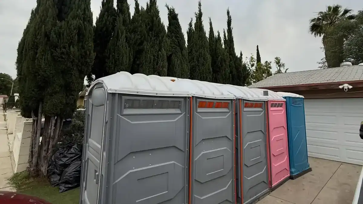 Row of portable toilets set on a gravel driveway